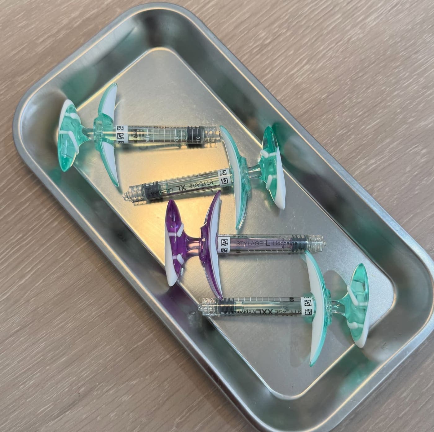 Prefilled filler syringes laid out on a steel tray